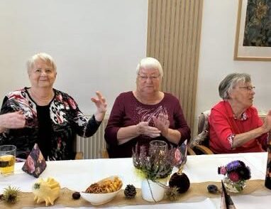 Drei Damen sitzen fröhlich am Tisch